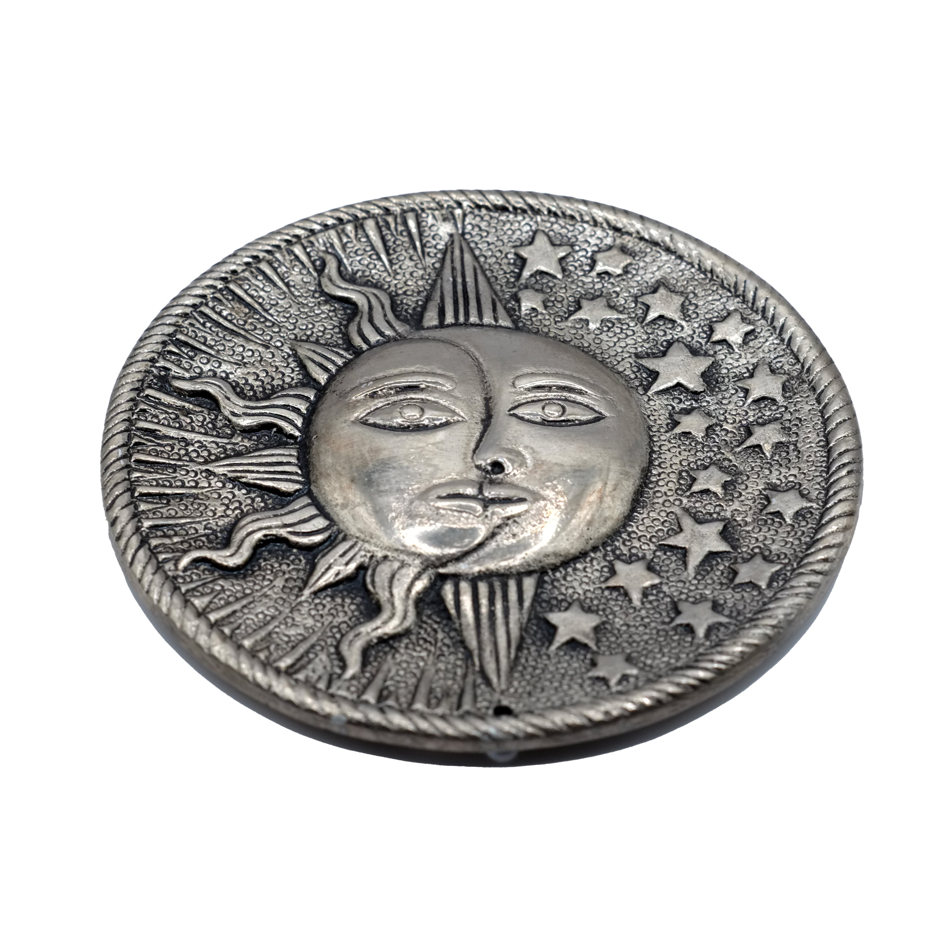 Ce porte-encens décoratif rond en aluminium recyclé, représente un soleil, une lune et des étoiles, symboliques d'une célébration céleste de la spiritualité.